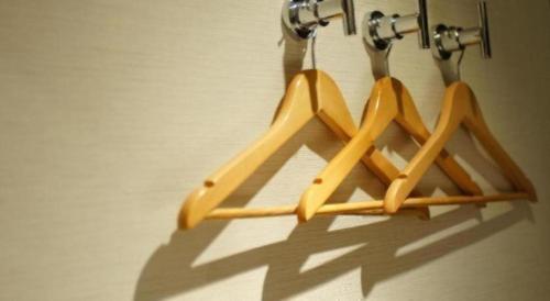 a group of wooden hangers hanging on a wall at Noble Park Hotel in Hong Kong