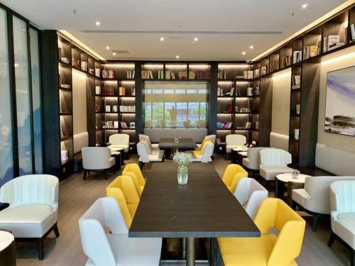 a dining room with a table and yellow chairs at H Life Hotel Nanshan Branch in Shenzhen