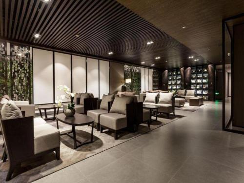 a waiting room with couches and tables and windows at H Life Hotel Nanshan Branch in Shenzhen
