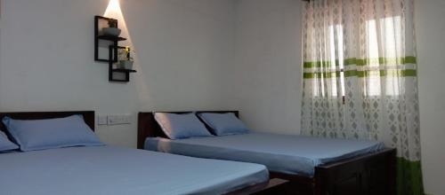 阿努拉德普勒Dewdula villa的有两张床和一扇窗户的房间