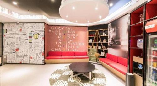 a room with a red couch and a coffee table at Ibis Nantong Qingnian in Nantong