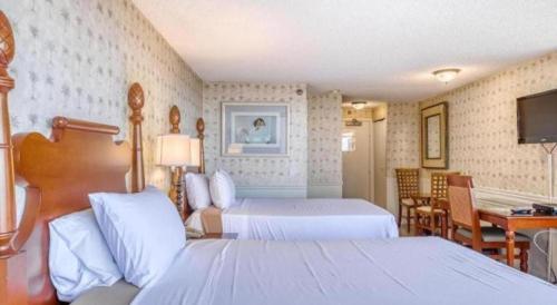 a hotel room with two beds and a desk at Marina Tower Waikiki in Honolulu