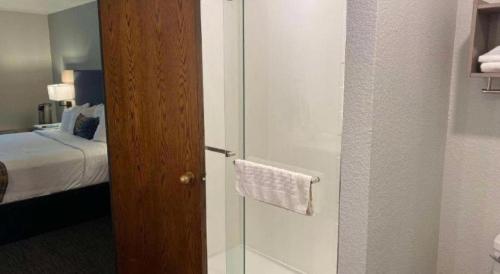 a bathroom with a glass shower with a bed at Best Western Lake Lucille Inn in Wasilla