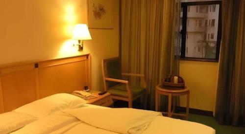 a hotel room with a bed and a chair at New Mong Kok Guest House in Hong Kong