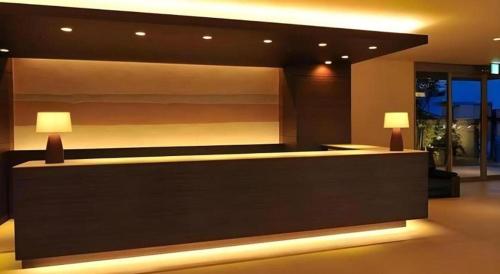 a lobby with a reception desk with two lamps at Kannawa Onsen Hotel Sansuikan in Beppu