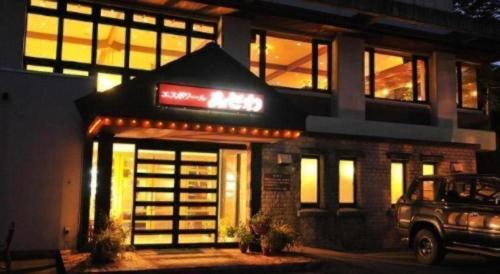 a building with a neon sign in front of it at Espoir Misawa in Hakuba