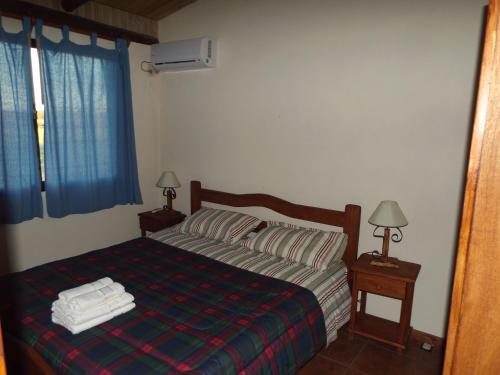 a bedroom with a bed with two lamps and two towels at El Remanso De Almiron in Termas de Almirón Inmotur