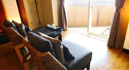 a living room with chairs and a couch and a window at Luxury Wa Hotel Kaze No Kaori in Ito