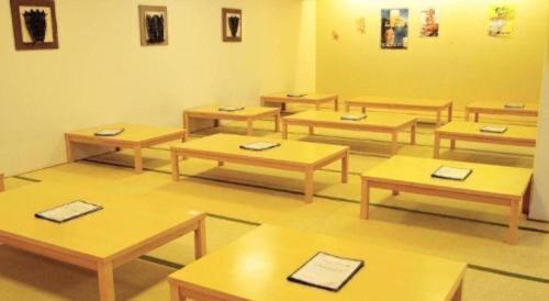 a classroom with wooden tables in a room at Ou Hotel in Yonago