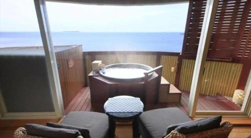 a balcony with a hot tub on a boat at Luxury Wa Hotel Kaze No Kaori in Ito