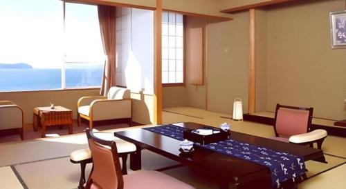 a living room with a table and chairs at Hotel Shofuen in Toyohashi