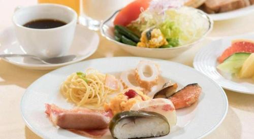 a table with plates of food and a cup of coffee at Hotel Harvest In Yonago in Yonago