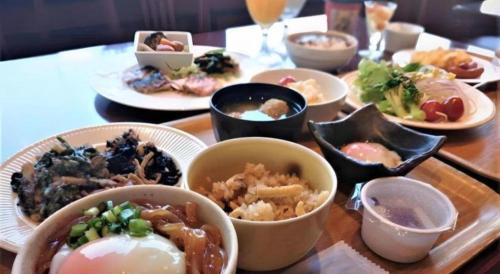 a table with plates of food on a table at Hotel Harvest In Yonago in Yonago