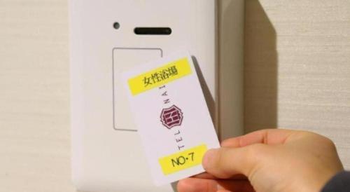 a person holding a wii remote with a note on it at Hotel Naito Kofu Showa in Kofu