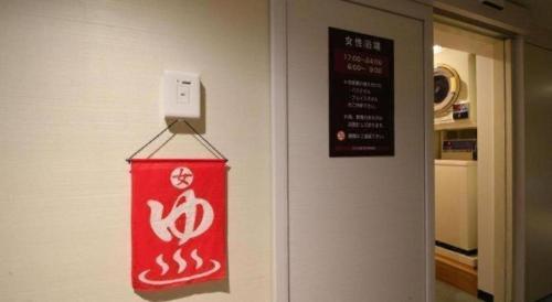 a sign is hanging on a wall in a room at Hotel Naito Kofu Showa in Kofu