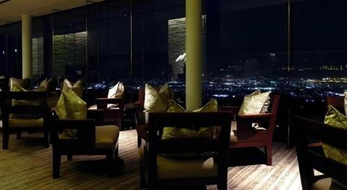 a restaurant with chairs and a view of a city at Nippondaira Hotel in Shizuoka
