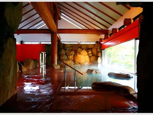 a room with a room with a stone wall at Hotel Tokoen in Yonago