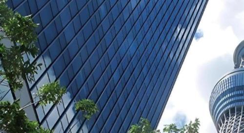 a tall blue building with trees in front of it at Hotel Shimbashi Sambankan in Tokyo