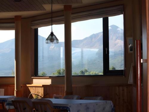 a dining room with a view of a lake and mountains at Petit Hotel Hoshi no Shizuku in Kitashiobara