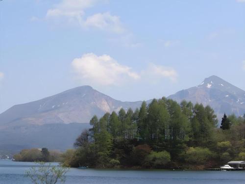 a view of a lake with mountains in the background at Petit Hotel Hoshi no Shizuku in Kitashiobara