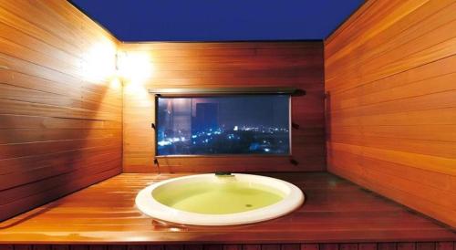 a bathroom with a bath tub with a window at Shirako New Seaside Hotel in Shirako