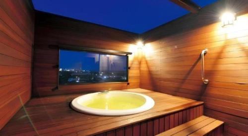 a bathroom with a bath tub with a window at Shirako New Seaside Hotel in Shirako