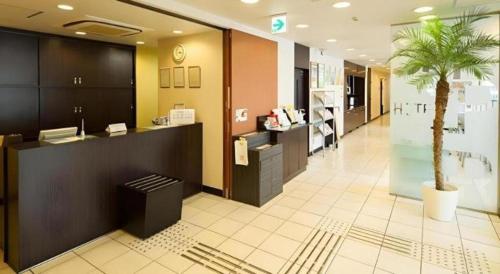 a lobby with a palm tree in the middle of a store at Super Hotel Satsuma Sendai in Satsumasendai