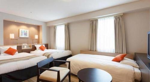 a hotel room with two beds and a chair at Akasaka Excel Hotel Tokyu in Tokyo