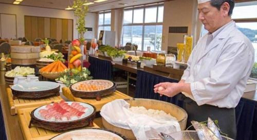 a man standing in a kitchen preparing food at Hamanako Lake Side Plaza in Hamamatsu