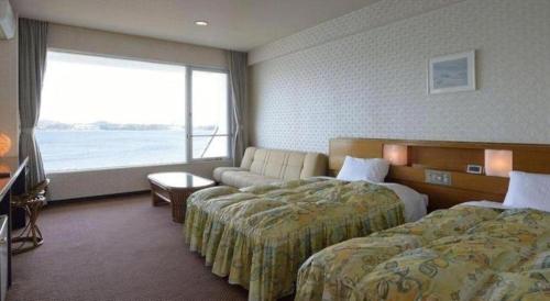a hotel room with two beds and a large window at Hamanako Lake Side Plaza in Hamamatsu