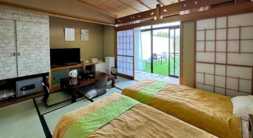 a bedroom with two beds and a large window at Taichou no Mori in Fukui