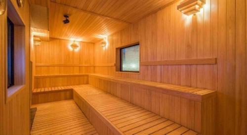 a sauna with wooden paneling and a small window at Hadano Yugawara Onsen Manyo no Yu in Hadano