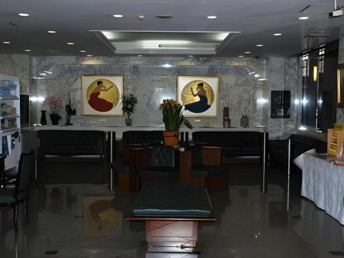 a restaurant with a table and chairs and paintings on the wall at Albert Hotel in Akita