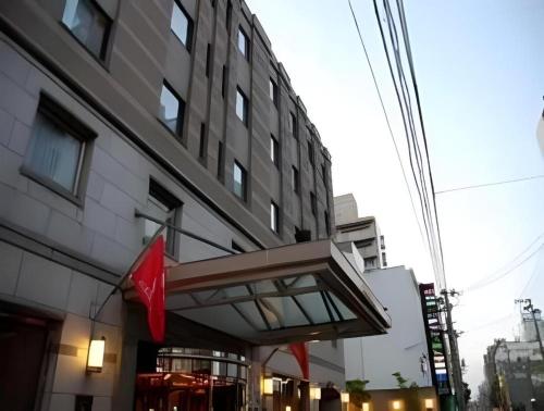 a building with a red flag in front of it at Albert Hotel in Akita