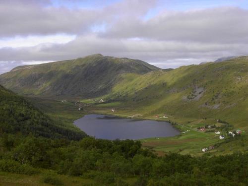 a lake in the middle of a valley with mountains at 7 person holiday home in Bøstad in Alstad