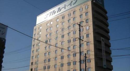 a tall building with writing on the side of it at Hotel Route Inn Furukawa Ekimae in Osaki