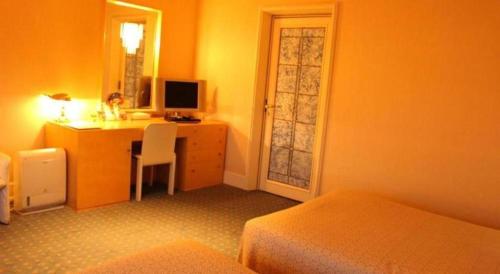 a bedroom with a desk with a computer in it at Gunma Royal Hotel in Maebashi
