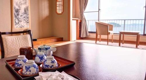 a table with a tray with blue and white vases on it at Hotel Himakasou in Minamichita