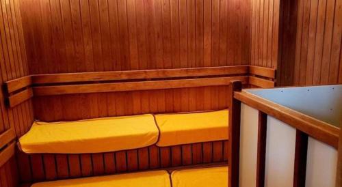 a sauna with a yellow bench in a wooden room at AI HOTEL OYAMA in Sano