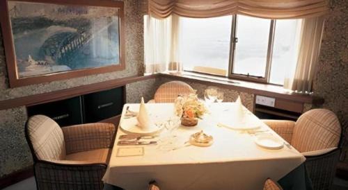 a dining room table with chairs and a white table sidx sidx sidx at Gunma Royal Hotel in Maebashi