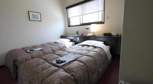 a couch in a room with a window at HotelNewYama in Yamanouchi