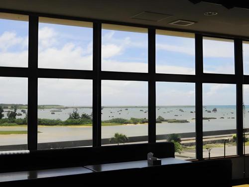 a room with a large window looking out at the water at Hotel Thida No Sato in Miyako Island