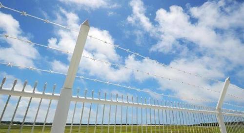 a white fence with barbed wire on top of it at Hotel Thida No Sato in Miyako Island