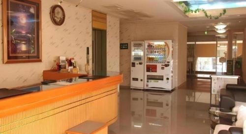 a restaurant with a counter and a refrigerator at Chino Station Hotel in Chino