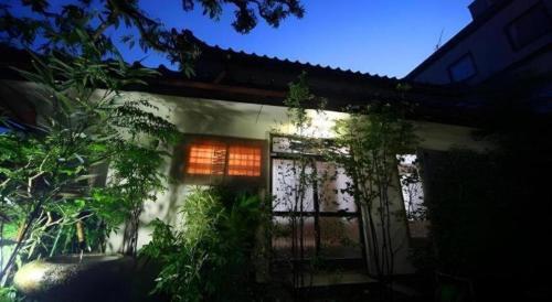 a house with a window and some plants in front of it at Suigetsurou Hotel in Takaoka