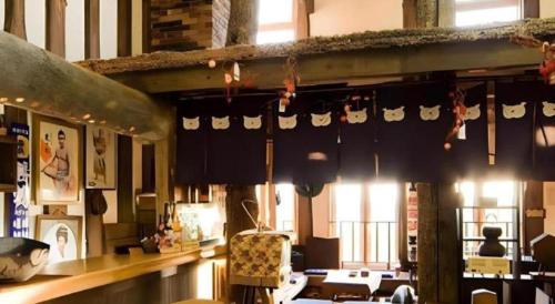 a room with a table and chairs in a building at Auberge Kitano Dandan in Abashiri