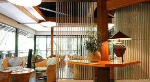 a lobby with chairs and a table with a lamp at Myoken Ishiharaso in Kirishima