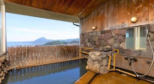 a pool of water in a building with a fence at Yukemuri no sato azumaya in Beppu