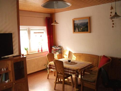 a dining room with a table and chairs and a window at Fewo Benedikta in Beuron