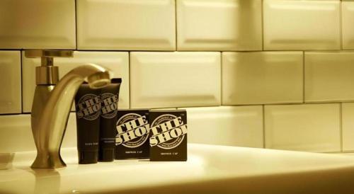 a bathroom sink with a tube of toothpaste and a faucet at The Shop Hotel in Kuala Kangsar